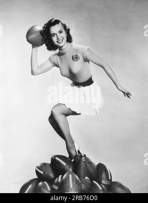 Hollywood, Kalifornien: c. 1953 Schauspielerin Debbie Reynolds macht sich bereit, einen Pass zu werfen, um die Fußballsaison zu starten. Stockfoto