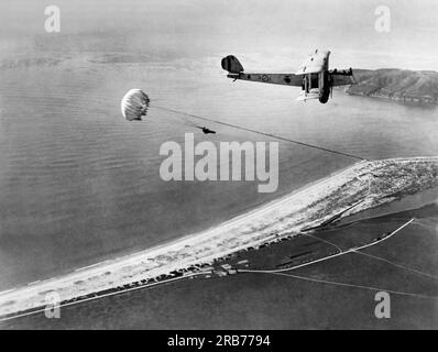 San Diego, Kalifornien: 11. Dezember 1926 Marine Fallschirmspringer W.A. Munktrick springt von einem Navy-Bomber 2500 Meter über der Coronado Naval Air Station. Ein zweiter Mann wartet auf dem Flügel. Stockfoto