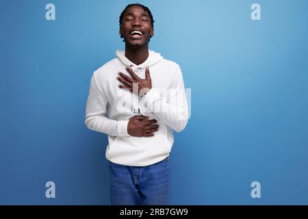 Netter afrikanischer 20s-Mann mit Dreadlocks auf blauem Hintergrund Stockfoto