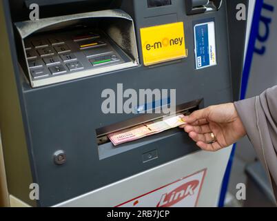 Yogyakarta-Indonesia, 1. Juli 2023: Eine Frau, die Geld vom Geldautomaten der Bank Mandiri in Yogyakarta, Indonesien, abhebt Stockfoto