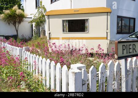 Ein Auto-Van-Parkplatz auf der Auffahrt mit Seitenfenster zum Blumengarten, Holzzaun in weiß, Kent England UK Stockfoto