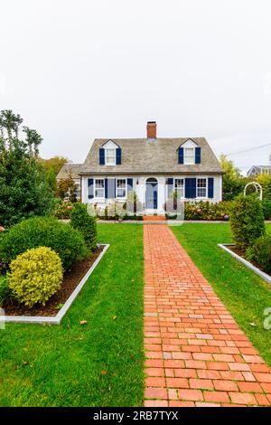 Symmetrisches Frontage House im lokalen Stil mit einem roten Backsteingarten Pfad, der zur Eingangstür in Provincetown, Cape Cod, MA, New England, USA führt Stockfoto