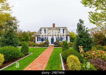 Symmetrisches Frontage House im lokalen Stil mit einem roten Backsteingarten Pfad, der zur Eingangstür in Provincetown, Cape Cod, MA, New England, USA führt Stockfoto