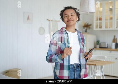 Birassische Teenager dehnen sich im Bett, tragen Unteraugenpflaster. Glückliches Mädchen liebt Hautpflege, morgendliche Schönheitsroutine. Stockfoto