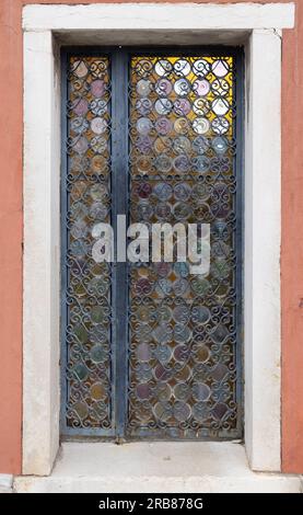 Vorderansicht einer klassischen Holztür mit Glasfenstern und dekorativem Metallgeländer Stockfoto