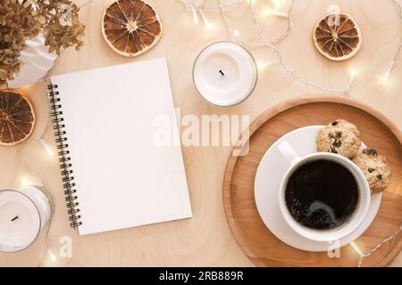 Zurück ins Leben, Zielliste-Konzept. Die Hand einer Frau schreibt in einem leeren Notizbuch auf einem Holztisch. Lösungen, Plan, Ziele, Checkliste, Ideenkonzept. Draufsicht, Stockfoto