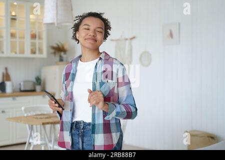 Birassische Teenager dehnen sich im Bett, tragen Unteraugenpflaster. Glückliches Mädchen liebt Hautpflege, morgendliche Schönheitsroutine. Stockfoto