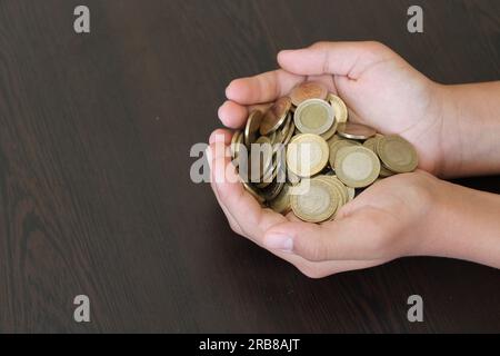 Türkische Münzen in der Kinderhandfläche. Akkumulierung und Einsparungen. Stockfoto