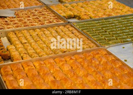 Gemischte Baklava-Sorten reihten sich auf Tabletts an. Selektiver Fokus eingeschlossen. Stockfoto