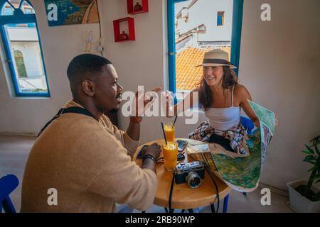Attraktive, multiethnische Freunde unterhalten sich während einer Pause in einer Café-Bar Stockfoto