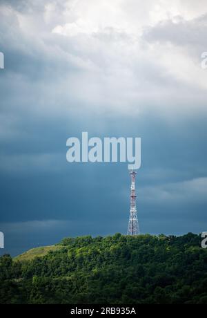 Funkturm auf einem Hügel am Abendhimmel vor Sturmregen Stockfoto