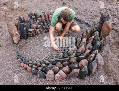 Dunbar, East Lothian, Schottland, Vereinigtes Königreich, 8. Juli 2023. European Stone Stacking Championship: Die letzten Tage des European Land Art Festivals mit Landkünstlern, die Landkunst schaffen. Im Bild: Der Landkünstler Jon Foreman kreiert eine Hühnerskulptur. Kredit: Sally Anderson/Alamy Live News Stockfoto