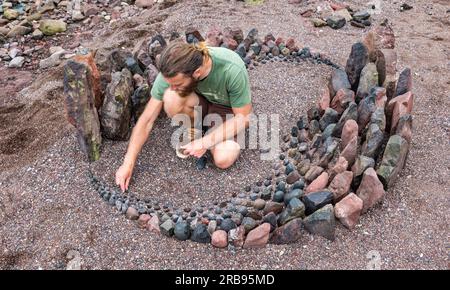 Dunbar, East Lothian, Schottland, Vereinigtes Königreich, 8. Juli 2023. European Stone Stacking Championship: Die letzten Tage des European Land Art Festivals mit Landkünstlern, die Landkunst schaffen. Im Bild: Der Landkünstler Jon Foreman kreiert eine Hühnerskulptur. Kredit: Sally Anderson/Alamy Live News Stockfoto