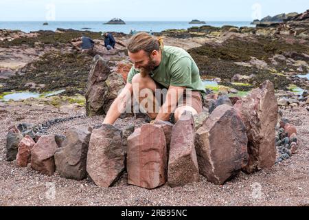 Dunbar, East Lothian, Schottland, Vereinigtes Königreich, 8. Juli 2023. European Stone Stacking Championship: Die letzten Tage des European Land Art Festivals mit Landkünstlern, die Landkunst schaffen. Im Bild: Der Landkünstler Jon Foreman kreiert eine Hühnerskulptur. Kredit: Sally Anderson/Alamy Live News Stockfoto