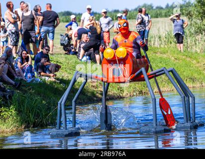 Pokrent, Deutschland. 08. Juli 2023. Mit einer aufwändigen Konstruktion beginnt „Spider-man“ an der traditionellen Badewannenregatta am Dorfteich. Insgesamt zehn Boote starten in zwei Rennen auf der Teichstrecke. Neben der Geschwindigkeit wird auch die Originalität der Boote vom Publikum bewertet. Kredit: Jens Büttner/dpa/Alamy Live News Stockfoto