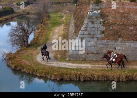 Palmanova, Italien - 20. Februar 2023: Reiter erkunden anmutig Palmanovas Bastionen und verbinden Reitabenteuer mit dem fesselnden Biest Stockfoto