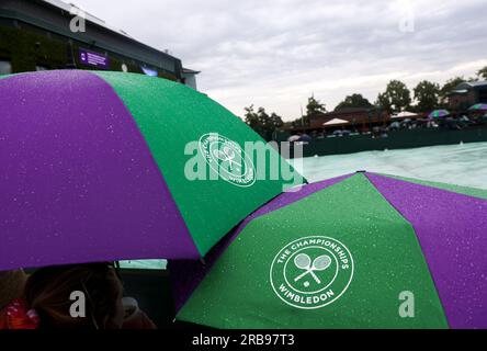 London, Großbritannien. 8. Juli 2023. Die Leute halten Regenschirme im Regen bei den Wimbledon Tennis Championships in London, Großbritannien, 8. Juli 2023. Kredit: Han Yan/Xinhua/Alamy Live News Stockfoto