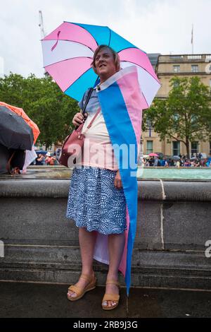 London, Großbritannien. 8. Juli 2023 Eine Person im Regen am Trafalgar Square, wo Blumen das Thema waren, während Trans+ Pride in London, eine Veranstaltung, um die Aufmerksamkeit auf die transgender Gemeinschaft zu lenken und zu transgender Freiheit und Gleichheit in Großbritannien und weltweit zu fordern. Kredit: Stephen Chung / Alamy Live News Stockfoto