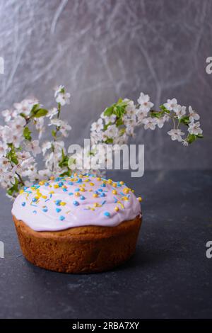 Frisch gebackenes hausgemachtes Osterbrot, natürlich gefärbte Eier und Frühlingsblumen. Frohe Ostern. Stilvoller paska mit Zuckerglasur und Streuseln, ein traditionelles U Stockfoto