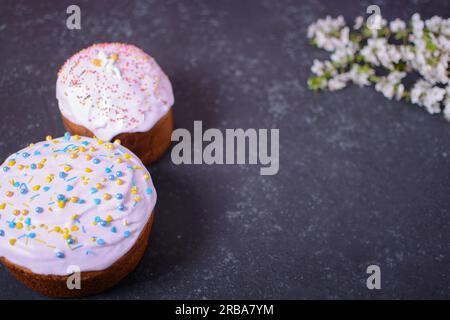 Frisch gebackenes hausgemachtes Osterbrot, natürlich gefärbte Eier und Frühlingsblumen. Frohe Ostern. Stilvoller paska mit Zuckerglasur und Streuseln, ein traditionelles U Stockfoto