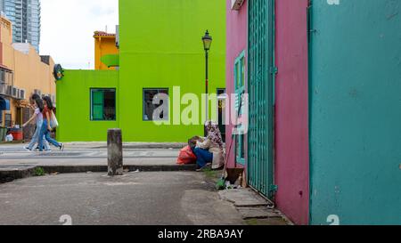 Kampong Glam, Singapur - 19. Dezember 2022: Leuchtend grüne und rosafarbene Wände mit einigen weiblichen Kinderwagen, die vor ihnen laufen. Aufgenommen im muslimischen Kampo Stockfoto