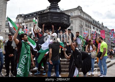 London, Großbritannien. 8. Juli 2023. Demonstranten klettern auf die Statue von Eros am Piccadilly Circus und halten die iranische Flagge hoch. Die Flaggen des Iran, Palästinas und Syriens werden festgehalten. Er schimpft mit Schweden von Unterstützern. Kredit: JOHNNY ARMSTEAD/Alamy Live News Stockfoto