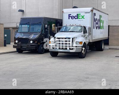 Buford, GA/USA - 30. Mai 2023: Am 30. Mai 2023 in Buford, GA, parkt ein UPS-Lkw neben einem FedEx-Lkw an der Laderampe eines Einkaufszentrums. Stockfoto
