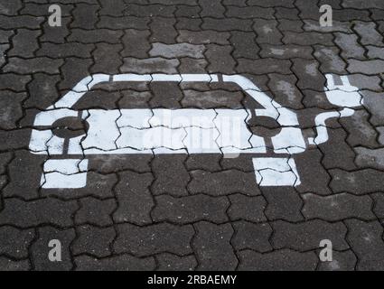 Bremen, Deutschland. 01. Juli 2023. 01.07.2023, Bremen. Ein Symbol für ein Elektroauto wird auf einem Parkplatz angezeigt, um Batterien an einer Ladestation für Elektroautos aufzuladen. Das weiße Symbol auf dem Bürgersteig verfügt über ein Kabel und einen Stecker. Kredit: Wolfram Steinberg/dpa Kredit: Wolfram Steinberg/dpa/Alamy Live News Stockfoto