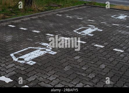 Bremen, Deutschland. 01. Juli 2023. 01.07.2023, Bremen. Symbole für Elektroautos sind auf einem Parkplatz zu sehen, um Batterien an einer Ladestation für Elektroautos aufzuladen. Die weißen Symbole auf dem Bürgersteig haben ein Kabel und einen Stecker. Kredit: Wolfram Steinberg/dpa Kredit: Wolfram Steinberg/dpa/Alamy Live News Stockfoto