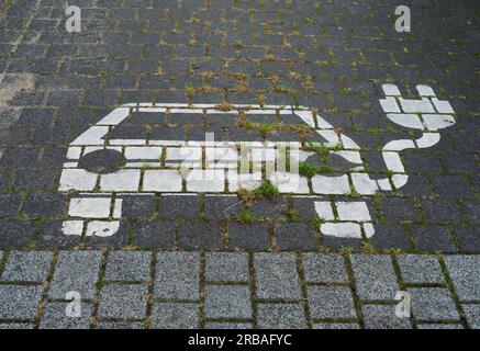 Bremen, Deutschland. 03. Juli 2023. 03.07.2023, Bremen. Ein Symbol für ein Elektroauto wird auf einem Parkplatz angezeigt, um Batterien an einer Ladestation für Elektroautos aufzuladen. Das weiße Symbol auf dem Bürgersteig verfügt über ein Kabel und einen Stecker. Kredit: Wolfram Steinberg/dpa Kredit: Wolfram Steinberg/dpa/Alamy Live News Stockfoto