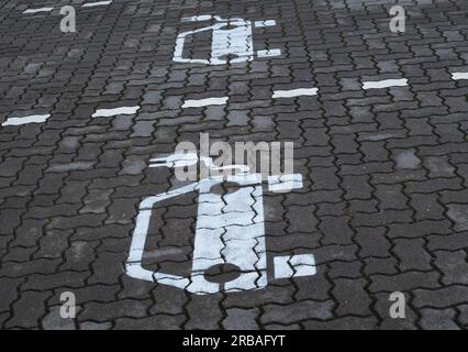 Bremen, Deutschland. 01. Juli 2023. 01.07.2023, Bremen. Symbole für Elektroautos sind auf einem Parkplatz zu sehen, um Batterien an einer Ladestation für Elektroautos aufzuladen. Die weißen Symbole auf dem Bürgersteig haben ein Kabel und einen Stecker. Kredit: Wolfram Steinberg/dpa Kredit: Wolfram Steinberg/dpa/Alamy Live News Stockfoto