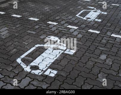 Bremen, Deutschland. 01. Juli 2023. 01.07.2023, Bremen. Symbole für Elektroautos sind auf einem Parkplatz zu sehen, um Batterien an einer Ladestation für Elektroautos aufzuladen. Die weißen Symbole auf dem Bürgersteig haben ein Kabel und einen Stecker. Kredit: Wolfram Steinberg/dpa Kredit: Wolfram Steinberg/dpa/Alamy Live News Stockfoto