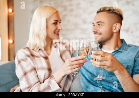 Junges Paar Toasting Weingläser zu Hause. Beziehung, Feier, Dating-Konzept Stockfoto