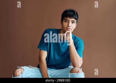 Junger, gutaussehender Mischrennfahrer, der vor der Kamera posiert. Mann-Schönheitskonzept Stockfoto