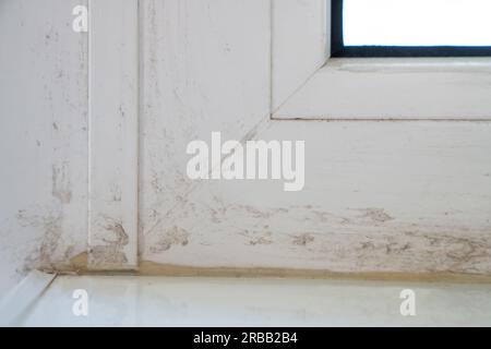 Teil des verschmutzten Fensterrahmens nach der Montage von Kunststofffenstern und dem Entfernen von Klebeband. Stockfoto