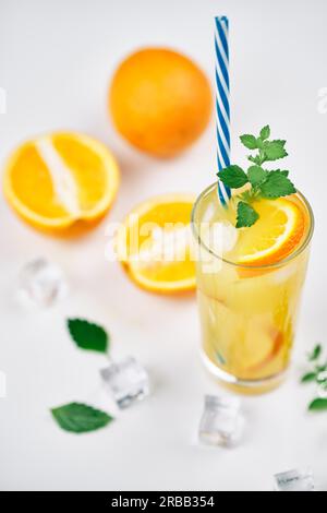 Cocktail mit Orangensaft, Minze und Eiswürfeln auf weißem Hintergrund. Party, Sommer, Drink Konzept Stockfoto