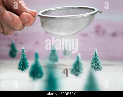 Ein Miniaturpaar tanzt im süßen Schnee im Wald Stockfoto