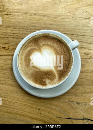 Tasse Cappuccino mit Milchschaum in Herzform, Holztisch, Stuttgart, Baden-Württemberg, Deutschland Stockfoto