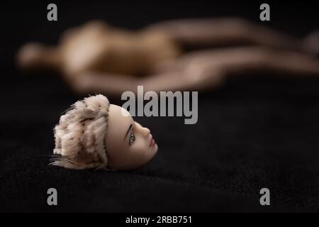 Der Kopf der Puppe liegt im Vordergrund und der Körper im Hintergrund Stockfoto