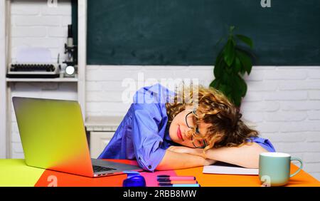 Zurück in die Schule. Schlafende Schülerin im Klassenzimmer. Junge Schülerin, die sich auf die Prüfungen vorbereitet. Hausaufgaben. Wissens-, Bildungs- und Lernkonzept. Ich Bin Müde Stockfoto