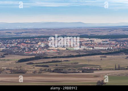 Stadt mit mehrstöckigen Häusern in einer kargen Winterlandschaft mit Bergen im Hintergrund Stockfoto