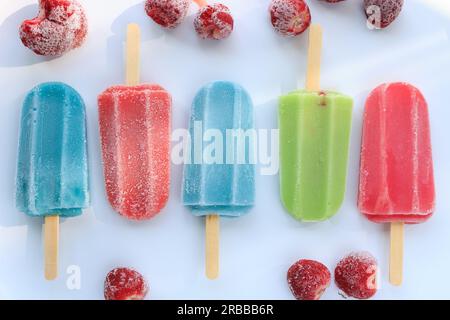 Eisiges, mehrfarbiges Eis am Stiel auf weißem Hintergrund. Stockfoto