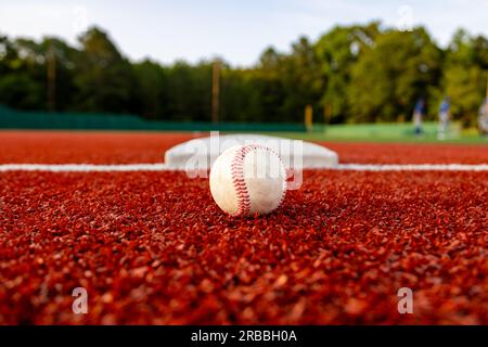 Baseball auf dem Feld neben der Basis für sportlichen Hintergrund mit Kopierbereich Stockfoto