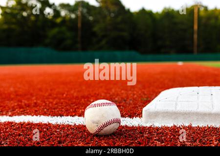 Baseball auf dem Feld neben der Basis für sportlichen Hintergrund mit Kopierbereich Stockfoto