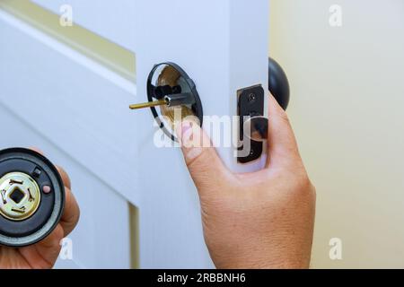 Mit Arbeiter bringt Schloss an der neuen Innentür an. Stockfoto