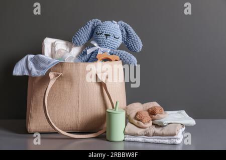 Mutters Tasche mit Babysachen auf grauer Kommode Stockfoto