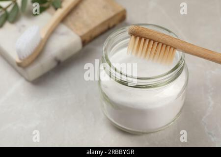 Bambuszahnbürste und Backpulver auf hellgrauem Marmortisch Stockfoto