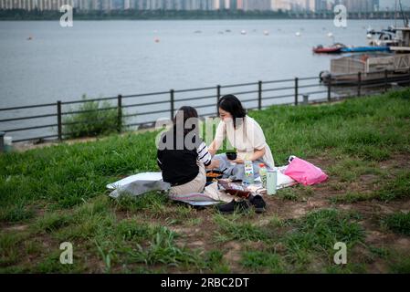 Picknick-Besucher im Yeouido-Park am Han River in Seoul, Südkorea, am 24. Juni 2023 Stockfoto