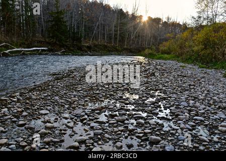Wunderschöner Blick auf den Sonnenuntergang über dem Flussufer mit Steinen im Nationalpark Stockfoto