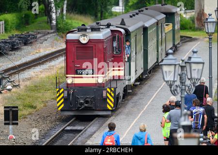 Oybin, Deutschland. 06. Juli 2023. Eine elektrische Lokomotive der Schmalspurbahn Zittau fährt in den Bahnhof des Kurorts. Nonensteine, Bechersteine oder der Berg Oybin, der in seiner Form einem riesigen Bienenstock ähnelt: Bizarre Felsformationen können in den Zittau Bergen entdeckt werden. Aufgrund der geologischen Ähnlichkeiten wird manchmal sogar von der "kleinen Schwester der sächsischen Schweiz" gesprochen. (Zu dpa: 'Beliebt für Kurzurlaube: Zittau Berge wollen entdeckt werden') Kredit: Robert Michael/dpa/Alamy Live News Stockfoto